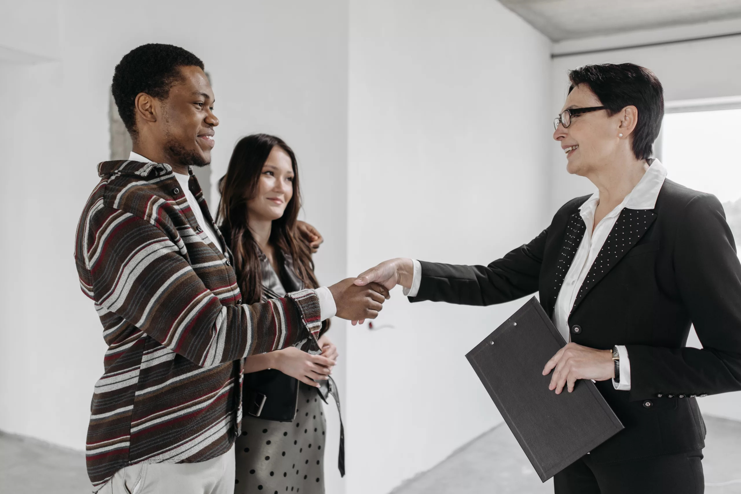 realtor shaking hands with couple